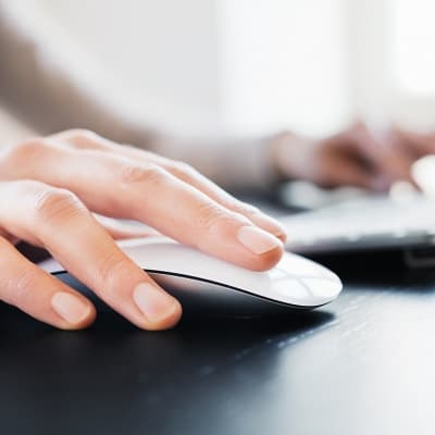 Close-up of female hand with computer mouse. Shallow DOF.