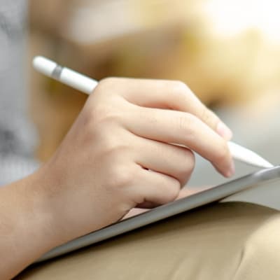 Close up of male hand using digital pen writing on digital tablet screen. Modern technology with electronic gadget concept
